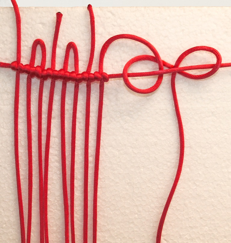 2. Используем технику плетения "макраме". Мы начинаем, связывая шнур узлом на горизонтальном шнуре-основе. Проложите столько шнуров, какую ширину мы хотим.
